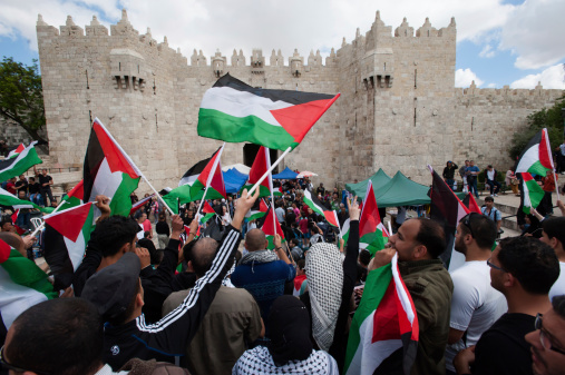 Flags of Israel and Palestine on broken cracked wall with two bandages