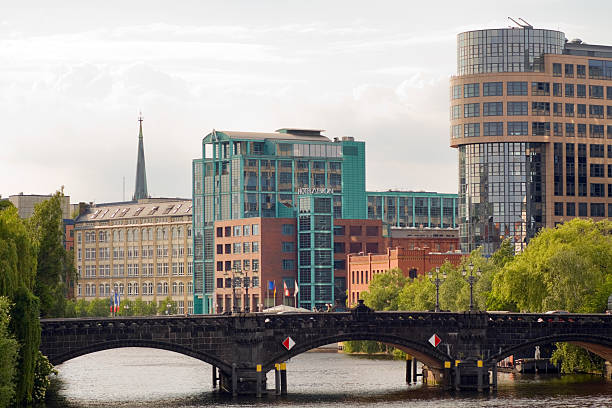 Spreebogen Berlin Moabit Berlin, Germany - May, 27th 2011: Spreebogen Berlin Moabit with bridge Moabiter Brücke and some modern buildings and architecture like hotel ABION. Some people are walking over bridge. River Spree is crossing in winding shape Berlin in East-West direction and offers many promenades and waterfronts for walking. View from station Bellevue. moabit stock pictures, royalty-free photos & images