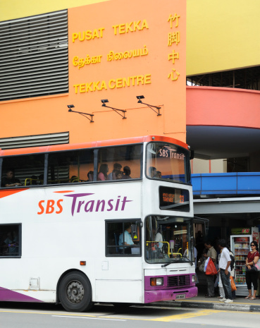 Singapore City, Singapore  - March 12, 2011: Tekka Centre. The image shows people boarding a bus  outside of the Tekka Centre in the Little India District of the city. The centre is a local landmark and contains an indoor market, shops and a wet market where goods from all over Asia can be purchased. SBS Transit has a fleet of 3000 buses in the city and runs 75% of all bus services.