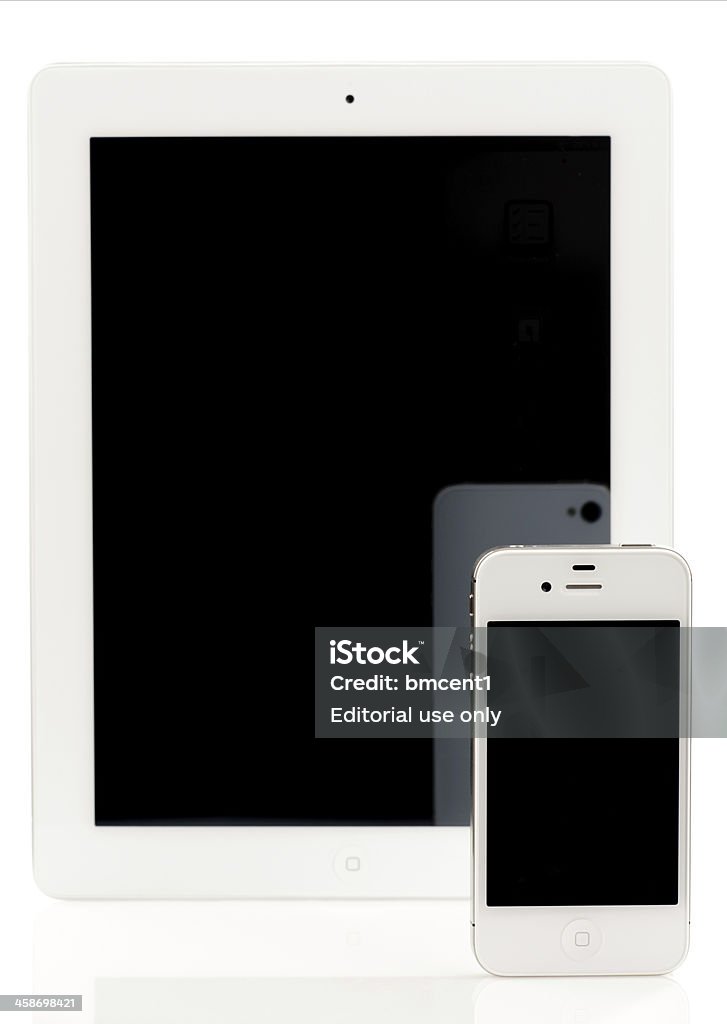iPhone 4S da Apple na frente do iPad 2, ambos branco - Royalty-free Apple Computers Foto de stock