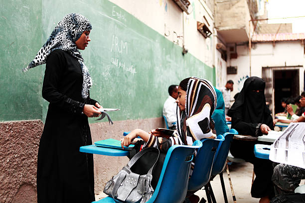 Teachers conducting classes in Street School run by ARM Karachi, Pakistan - July 12, 2010: Male and female teachers conducting classes in Street School run by ARM child and youth welfare in Lyari. All classes run side by side in one of the congested lane of Lyari one of the oldest slum in town. pakistan school children stock pictures, royalty-free photos & images