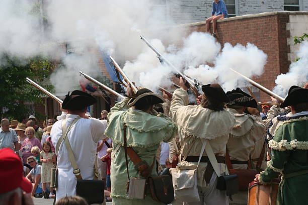 Colonial Reenactment Chestertown, Maryland, USA – May 26, 2007:  Members of a Colonial army reenactment group demonstrate musket fire during the Annual Chestertown Tea Party Parade. chestertown stock pictures, royalty-free photos & images