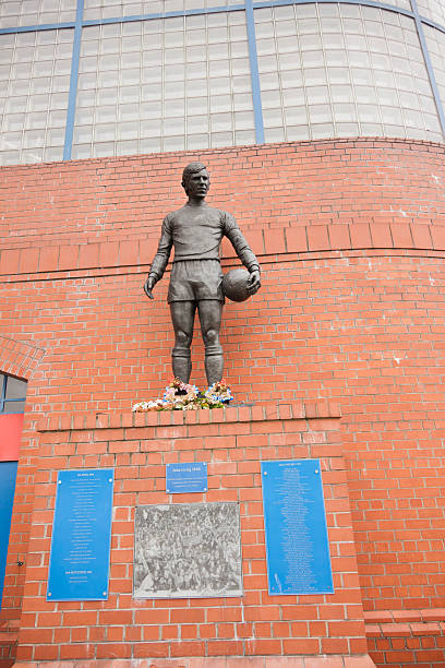 Ibrox Stadium Disaster Memorial, Glasgow Glasgow, UK - July 12, 2011: A statue of John Greig outside Ibrox Stadium, Glasgow, the home ground of Rangers Football Club. The statue commemorates those killed in the first Ibrox Disaster when a stand collapsed in 1902, in a crush on a stairway in 1961, and in the second Ibrox Disaster in 1971 when 66 died in a crush when leaving the ground. John Greig was the Rangers captain at the time of the 1971 disaster. The memorial was created by sculptor Andy Scott and unveiled on 2 January 2001. ibrox stock pictures, royalty-free photos & images