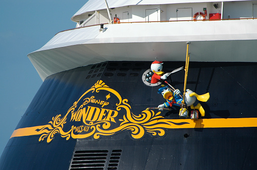 Port Canaveral, FL, USA - May 27, 2007: The cruise ship Disney Wonder stern view as it leaves port.. The Disney character Donald Duck paints the stern while one of his his mischievous nephews prepares to cut his support line.