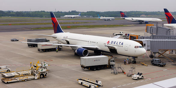 Narita, Japan - June 5, 2011: A Boeing 767 registered to Delta Airlines is parked at a gate while other jets taxi in the background at Narita International Airport, an airport serving the greater Tokyo area of Japan. Narita handles the majority of international passenger traffic to and from Japan, and is also a major connecting point for air traffic between Asia and the Americas.