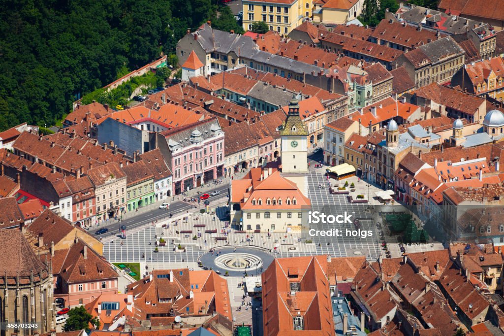 View over the town of Brasov in Romania Brasov, Romania - June 15, 2011: High Angle view of the town of Brasov in Romania centred on the Town Hall building. People can be seen going about their activities in the town square. Brasov Stock Photo