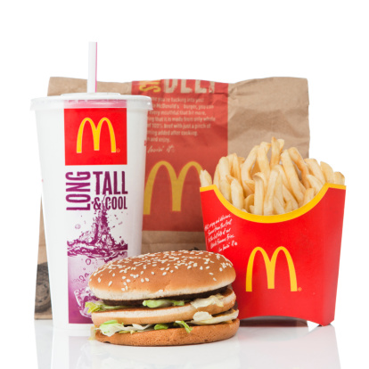 Newcastle upon Tyne, England - March 5, 2011: McDonald\\'s Big Mac value meal isolated on a white background.  A Big Mac, fries and a coke sitting on a reflective surface.