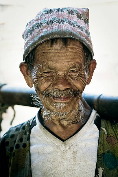 retrato de viejo nepali hombre mirando a la cámara - dhaka topi fotografías e imágenes de stock