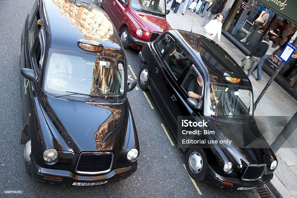 London Black Taxi Cabs Outside Harrods Department Store, Elevated View London, United Kingdom - September, 26th 2009: Black taxi cabs outside Harrods department store, Brompton Road, Knightsbridge, central London.Possibly the most famous department store in the world, Harrods of London was founded in 1834 by Charles Henry Harrod, since then its green and gold livery has become synonymus with quality, service and exclusivity. Activity Stock Photo