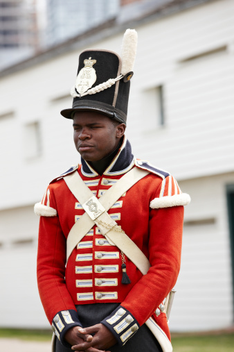 Toronto, Canada - July 2, 2011: Young black student carrying out re-enactments of the early Canadian Army in the historic red and white uniforms of the 19th Century