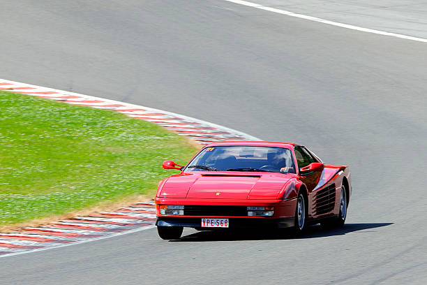 Spa, Belgium - June 29, 2008: Rec Ferrari Testarossa sports car driving around the Spa Francorchamps race track. Two persons are sitting inside the car.