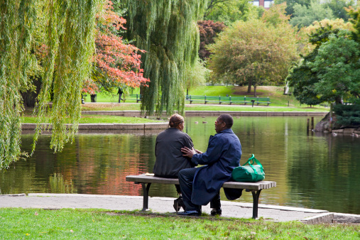 Boston, USA 15th October 2010, An African-American couple talking on a bench next to the pond in Boston Common, the public park in Boston, Ma.