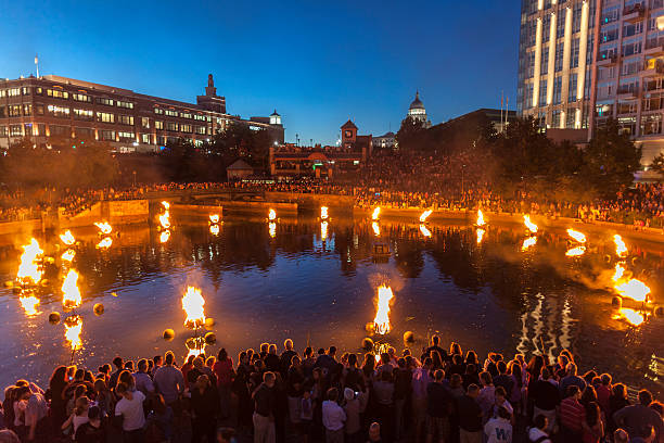 Waterfire, an outdoor art event in Providence Rhode Island "Providence, Rhode Island, USA - August 24, 2013: People line the banks of the Providence River to enjoy Waterfire. Waterfire is a free community arts event on the Providence River which begins at sunset. Waterfire was started by Barnaby Evans in 1994, and takes place about every other weekend through the summer." providence rhode island photos stock pictures, royalty-free photos & images