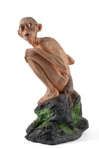 Gera, Germany - August 5, 2011: Smeagol is a figurine of Resin from Sideshow Weta. Weta was the company who made the figurines of the Triology Lord of the Rings from Tolkien. Smeagol - later called Gollum is one of the enemys in this film/novel. Here shown sitting on a stone with catched fish. Figurine is about 15cm high.