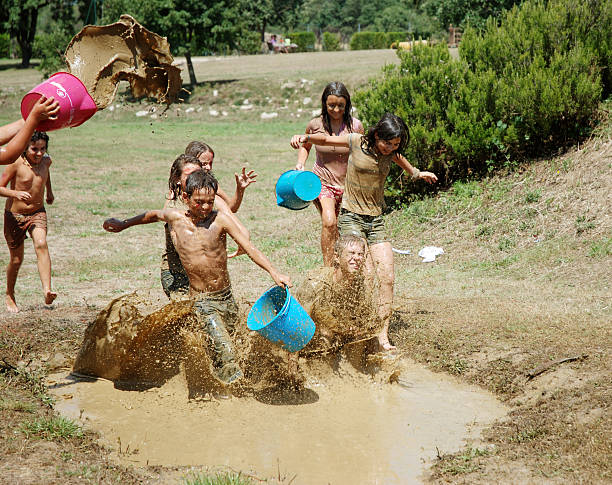 Children playing on mud hole stock photo