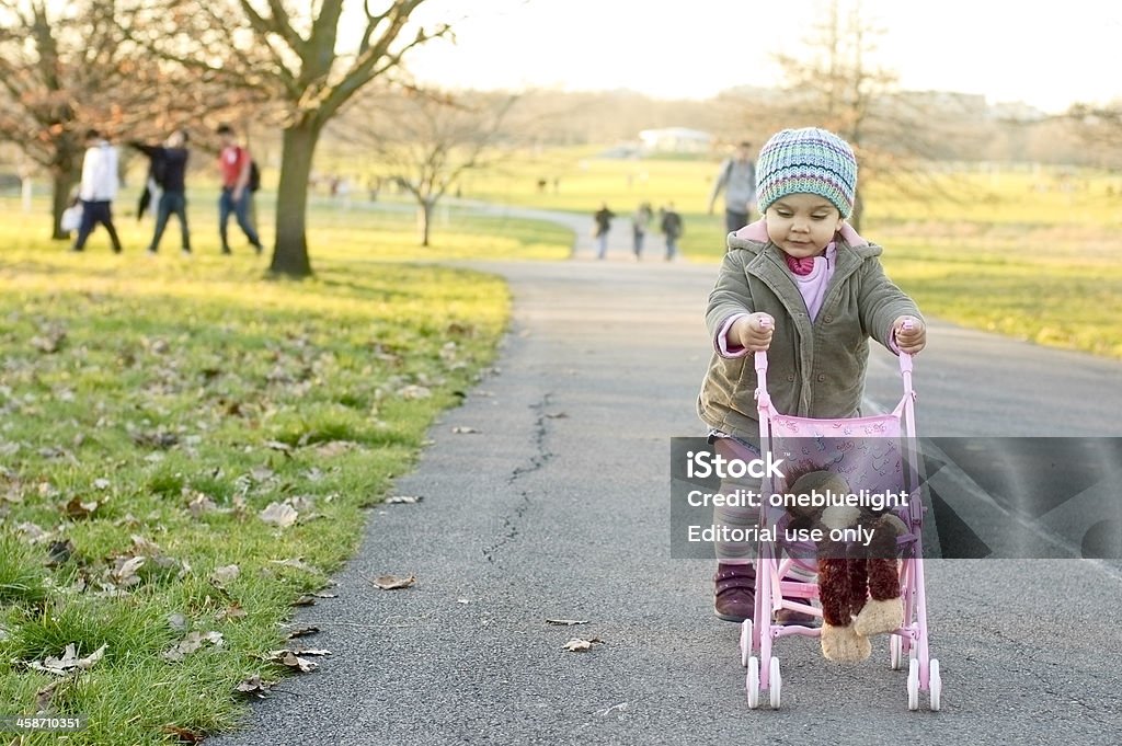 / a figlio/a (18 mesi) Spingere il Suo bambino Troller - Foto stock royalty-free di 12-17 mesi