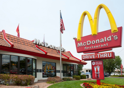 Albuquerque, New Mexico, USA - July 2, 2011: Traditional-looking McDonald's fast food restaurant with the characteristic company logo pole sign. McDonalds is the world's largest chain of hamburger fast food restaurants. McDonald's restaurants are found in 119 countries around the world and serve 58 million customers each day. Approximately 15% of McDonald's restaurants are owned and operated by McDonald's Corporation directly. The remainder are operated through a variety of franchise agreements. McDonald's predominantly sells hamburgers, various types of chicken sandwiches and products, French fries, soft drinks, breakfast items, and desserts.