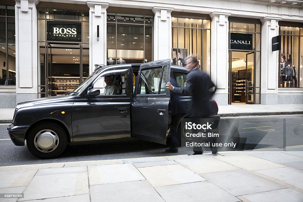 Empresario cómo llegar en taxi en frente de la tienda de moda - Foto de stock de Londres - Inglaterra libre de derechos