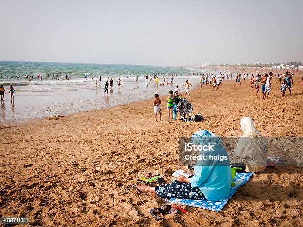 Asliah Morocco Woman Wearing Headscarves Sit On The Beach Stock Photo - Download Image Now