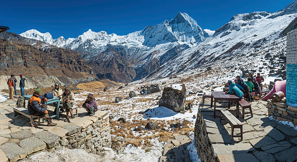 sherpas и портье, расслабляясь в annapurna базовый лагерь гималаи, непал - annapurna range стоковые фото и изображения