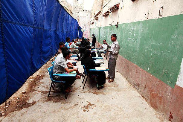 gli insegnanti di condurre lezioni in strada scuola eseguire per braccio - community outreach social worker teenager poverty foto e immagini stock