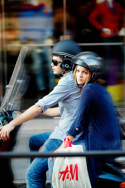 Young couple riding a scooter after shopping in Italy stock photo