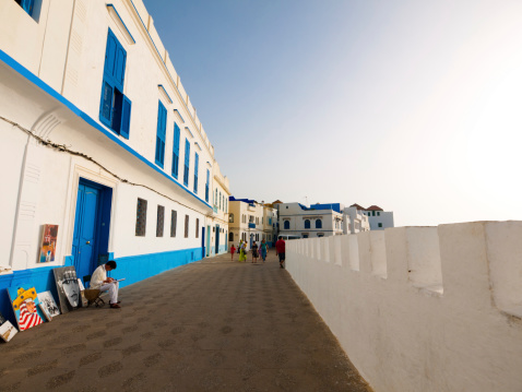 Asilah, Morocco- July 9, 2010: Walled coastal walkway in the Medina, Asilah - where local artists sell their work