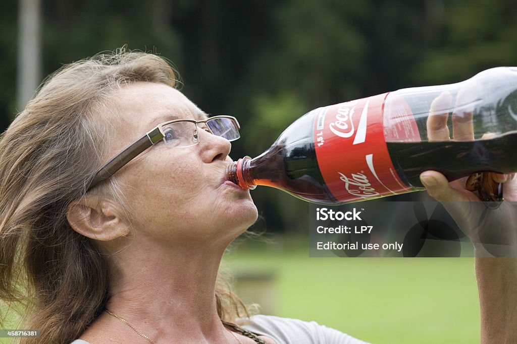 Senior donna bere Coca Cola - Foto stock royalty-free di Cola