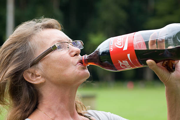 Starszy kobieta picia Cola – zdjęcie
