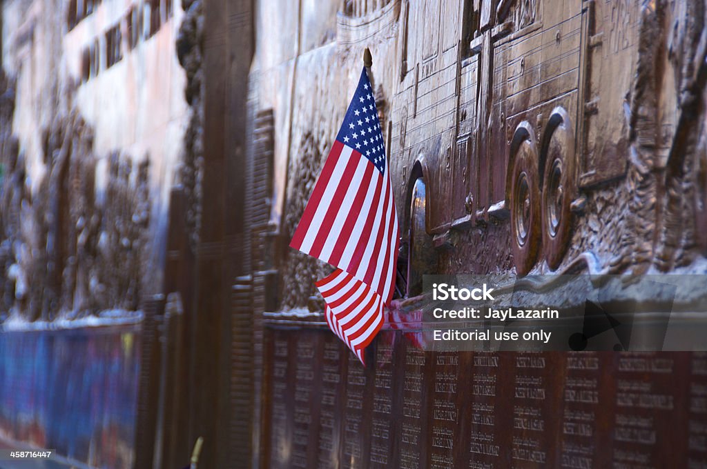 American flag at FDNY Memorial Wall, Ground Zero New York City, USA - May 6, 2011: A small American flag was left attached to the FDNY ( Fire Department of New York City) Memorial Wall that commemorates the 343 men killed on September 11, 2001. The scene is on the day after President Obama visited Ground Zero as thousands of people came to the site after the U.S. Special Forces killed Osama Bin Laden in Pakistan. It is located on the Liberty & Greenwich Street firehouse of Engine & Ladder No.10, across from Ground Zero, World Trade Center. September 11 2001 Attacks Stock Photo