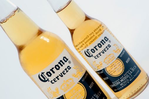 Buenos Aires, Argentina - June 10, 2011: Indoors product shot of two Corona Beers on the white background. Two bottles together the differents size . Corona is manufactured in Mexico by Cerveceria Modelo.