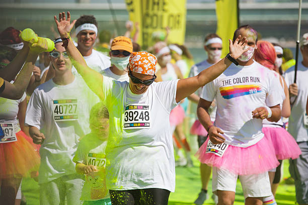 competitors at a ColorRun in Cologne "Cologne, Germany - July 21, 2013: competitors at a ColorRun in Cologne, Germany. Color Run is since a few years a world wide upcoming charity event with fun character. The competitors are sprayed with color powder." cologne germany stock pictures, royalty-free photos & images