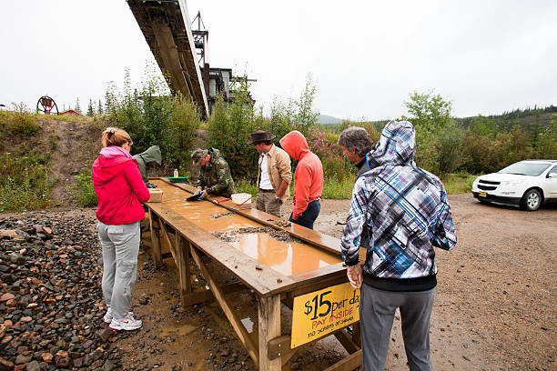 Two native men are panning gold in Chicken,Alaska,USA Chicken,Alaska,USA... July, 23 2010 Two native men are panning gold in Chicken,Alaska,USA on a rainy day...visitors are watching them at work alaska gold rush stock pictures, royalty-free photos & images