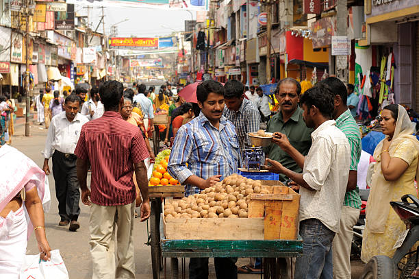 Thiruvananthapuram, India - January, 14th 2011 Typical Indian street market, this one is in Trivandrum. The Connemara market is very big and famous and always crowded. In the foreground is a vendor checking the weight of potatoes for a potential customer. The market is always crowded with people who want to do their shopping from Trivandrum and so it can be said that it is one of the attractive places and is called  market in Trivandrum.The city of Trivandrum is a shopperaas paradise and the Connemara market has all the shops that one can possibly think of.