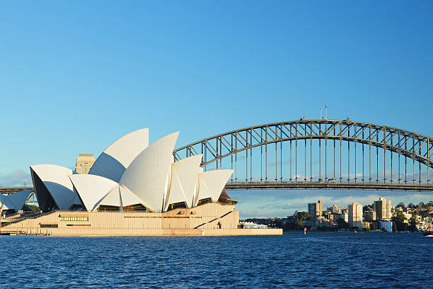 Sydney Opera House and the Harbor Bridge "Sydney, Australia - August 17, 2012: Australian architectural icons - the opera house and the harbor bridge - situated on the Sydney harbor." editorial architecture famous place local landmark stock pictures, royalty-free photos & images