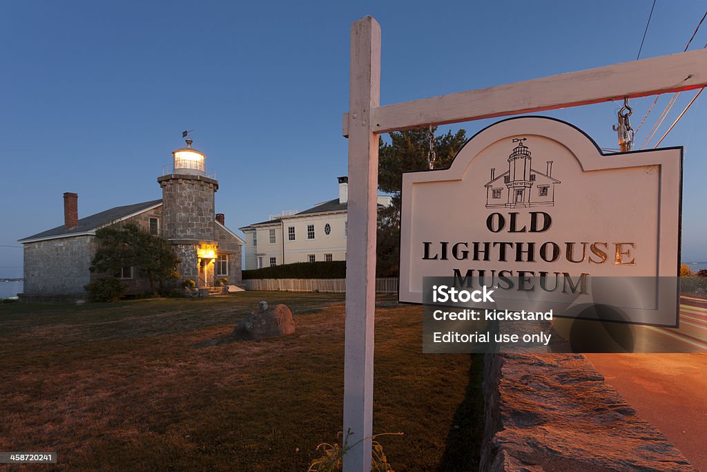 Stonington Harbor Light "Stonington, CT, USA - August 7, 2010: A sign reading ""Old Lighthouse Museum"" points visitors to the Stonington Harbor Light, a granite structure built in 1824." Blue Hour - Twilight Stock Photo