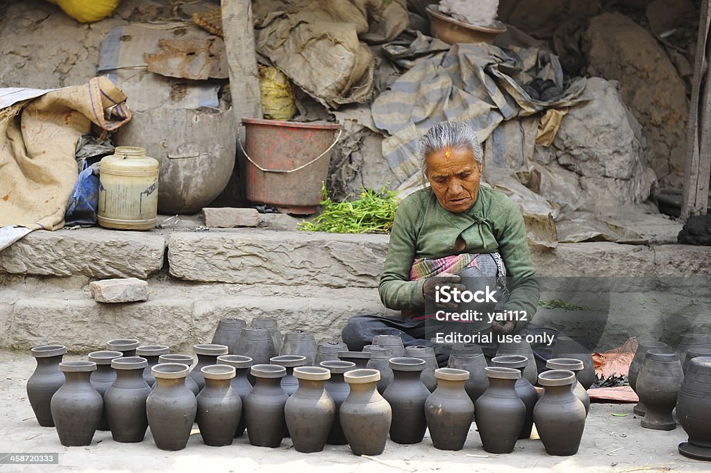 Earthenware at Bhaktapur Bhaktapur, Nepal - March 25, 2009: Nepalese trader sells a vases at Bhaktapur, Nepal. Bhaktapur is listed as a World Heritage by UNESCO for its rich culture, temples, and wood, metal and stone artwork. Active Seniors Stock Photo