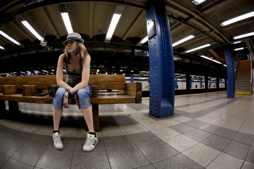 New York City, USA - May 26, 2010: Young woman waiting for subway on Canal Street Station in NYC.
