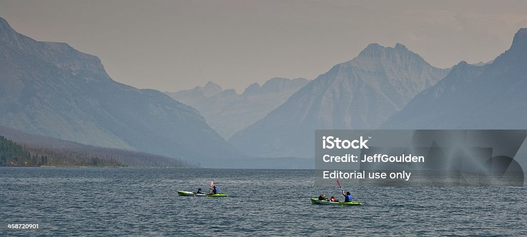 Kayakers on Lake McDonald Glacier National Park, Montana, USA - August 12, 2013: This family in two kayaks is paddling across Lake McDonald on a hazy day. Family Stock Photo