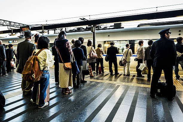 Kyoto, Japan - October 20, 2012: People waiting for their trains in the Kyoto train station. Inaugurated in 1997 it is the second largest station in Japan. Build by architect Hiroshi Hara it has an extension of 238000 square meters and is 70 meters high and its modernity contrasts with the traditional city of Kyoto.