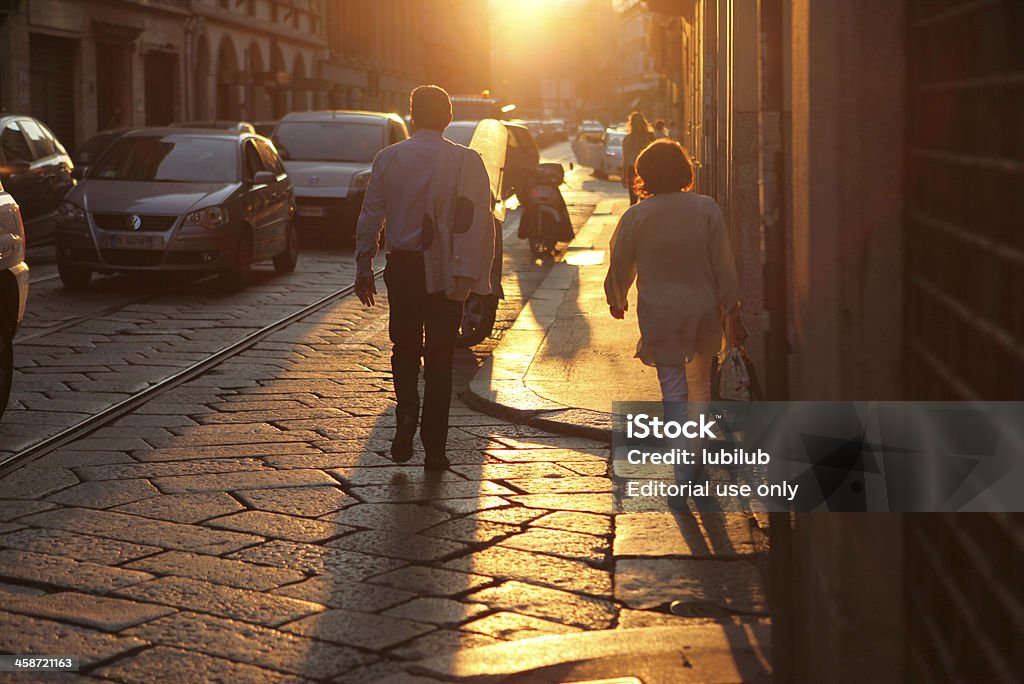Uomo e donna a piedi al tramonto a Milano, Italia - Foto stock royalty-free di Abbigliamento casual