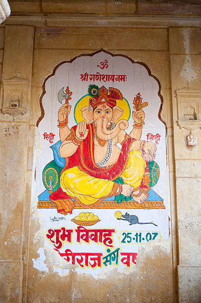 Jaisalmer, India - January 4, 2011: A wedding notification painted on the house where the bride's family lives, notifying every person reading the sign that a wedding is going to take place on November 25, 2007, and everybody is invited to attend the wedding. The god Ganesh with its elephant nose greeting with its hands. The sign is written in sanskrit. In India, wedding invitations are not sent out by mail, but rather painted to walls. Weddings can have up to thousands of guests and the ceremony may last for days. Ganesh is considered good luck. These invitations remain on the house walls for years.