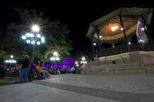 Plaza Zaragoza, Hermosillo Hermosillo,Mexico - October 20, 2011: Plaza Zaragoza, Hermosillo. A crowd has gathered for listening to a concert in the central kiosk. In the background, illuminated in purple, is the Town Hall. wide angle photos stock pictures, royalty-free photos & images