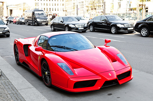 Berlin, Germany - April 20, 2012: With F1 technology, the Enzo Ferrari is a 12 cylinder mid-engine berlinetta named after the company's founder. Built in 2002 with carbon-fibre body. It was designed by the japanese Ken Okuyama and has a limited production run of 349 units. Unter den Linden street in Berlin, close to the Brandenburg Gate