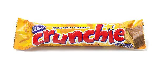 Crunchie Sponge Toffee Chocolate Candy Bar "Toronto, Canada - May 8, 2012: This is a studio shot of a Crunchie sponge toffee candy bar made by Cadbury isolated on a white background." cadbury plc photos stock pictures, royalty-free photos & images
