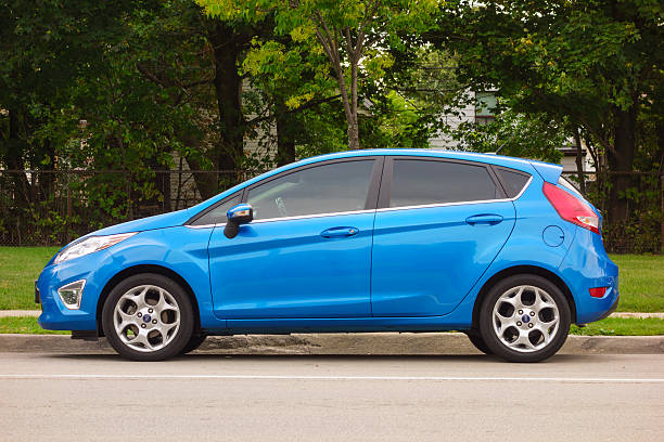Ford Fiesta "Hamilton, Canada - September 15, 2013: Side view of a blue colored sixth generation Ford Fiesta compact car parked on the street." 2010 stock pictures, royalty-free photos & images