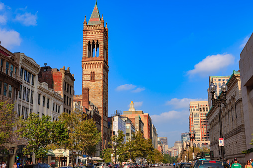 Boston, USA - September 05, 2011: Boylston Street in Boston, Massachusetts with the tower of the Old South Church on a bright September afternoon; the sky is clear ad blue with some low white clouds. Cars are parked by the sidewalk and some people are seen on the sidewalk, shopping. Photo shot in the afternoon sunlight; horizontal format; copy space. Camera: Canon EOS 5D MII. Lens: Canon EF 24-70 F2.8L USM