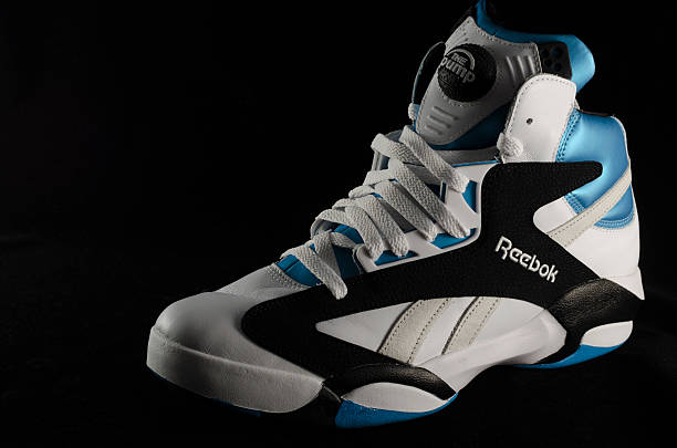 Reebok Shaq Attaq Basketball Sneaker "Bergen County New Jersey, USA - September 8, 2013: A Reebok ""Shaq Attaq"" in white and blue colorway photographed against a black background. The ""Shaq Attaq"" sneaker was originally released in 1992, featuring the ""Pump"" technology and were endorsed by the, then, Orlando Magic Center, Shaquille O'Neil. The sneakers were re-released in 2002 and 2013." reebok stock pictures, royalty-free photos & images