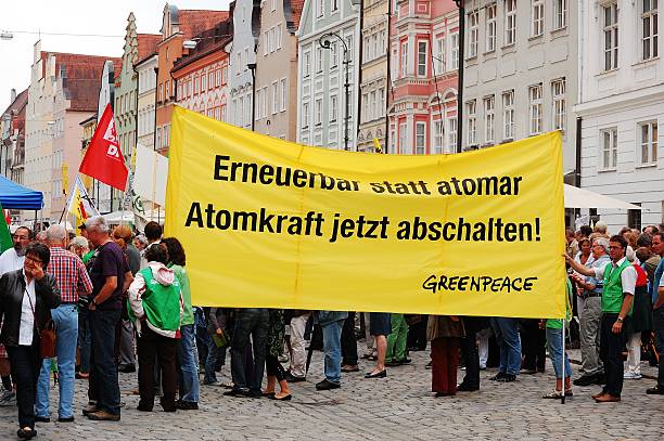 Greenpeace protest "Landshut, Germany-June 11,2011:Unidentified activist holds banners at a demonstration against nuclear power and pro renewable energy." greenpeace activists stock pictures, royalty-free photos & images