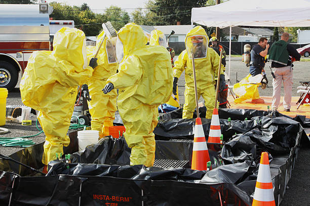 HAZMAT Team Members Chemical Suit Clean Up "Eugene, Oregon, USA aa November 3, 2011: Fire departments and emergency response teams will conduct disaster preparedness drills. This drill is the combination of various fire departments from Eugene, Lane County, and other nearby emergency services." drill team stock pictures, royalty-free photos & images